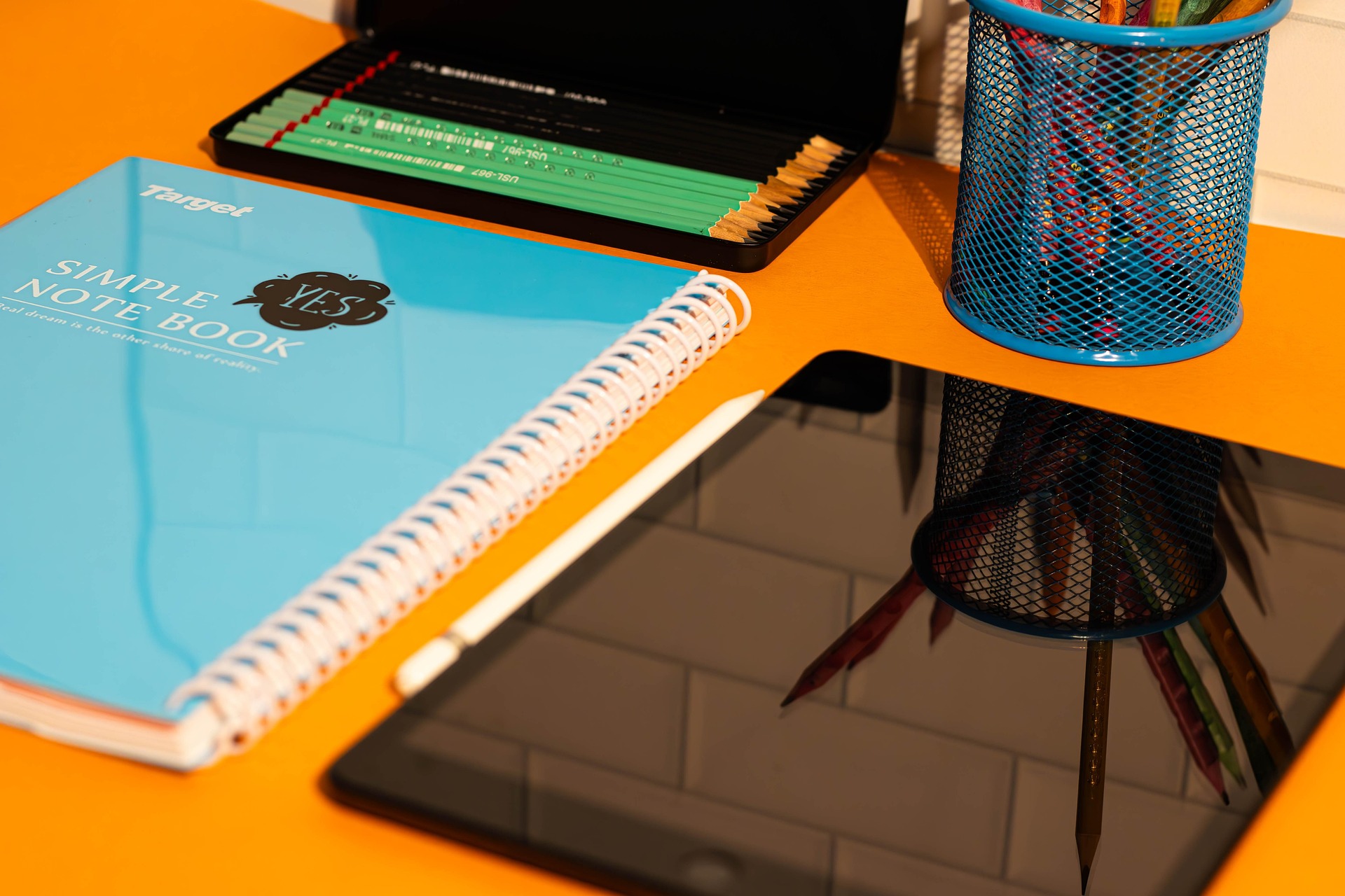 The corner of a white spiral notebook against a bright red background